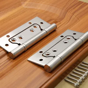 Macro shot of 4-inch stainless steel door hinges with screws on a wooden surface