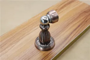 Detail of red bronze magnetic door stopper with European vintage embossed base and wood texture