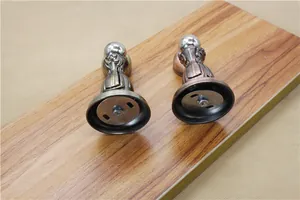 Detail of antique bronze and red copper magnetic door stoppers on wood texture
