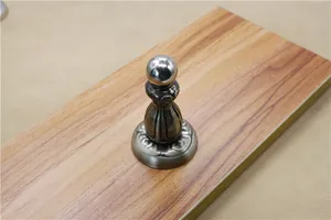 Close-up of antique bronze magnetic door stopper on wood grain texture base