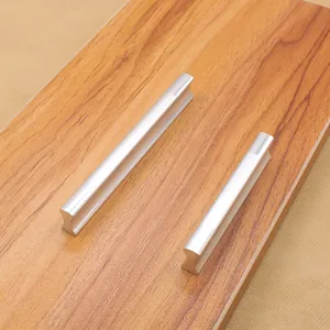 Detail of solid aluminum alloy cabinet handles with matte silver finish on wood surface