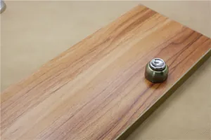 Macro view of magnetic door stopper in antique bronze finish on a wood surface