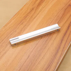 Close-up of matte silver aluminum furniture handle with dual mounting holes on wood