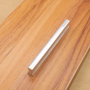 Modern minimalist aluminum alloy furniture handle with matte silver finish on wood board