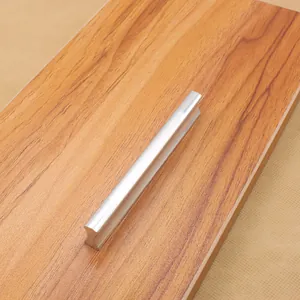 Detail view of a matte silver aluminum alloy handle on a wooden surface cabinet