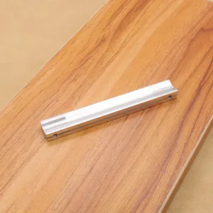Macro detail of silver aluminum cabinet handle with curved groove on wood surface