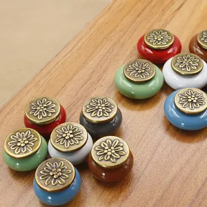 Macro view of multi-color ceramic drawer knobs with floral embossed antique bronze caps