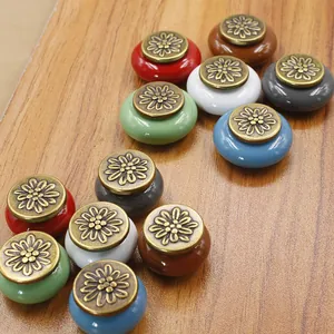 Detailed close-up of retro colorful ceramic cabinet knobs with embossed floral metal tops