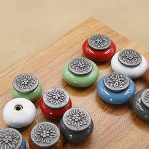 Top view of multi-colored ceramic cabinet knobs with antique floral silver metal caps