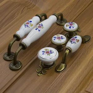 European floral ceramic furniture handles with bronze bases on wooden cabinet door