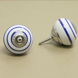 Close-up of white ceramic knobs with blue circular stripes and silver metal base