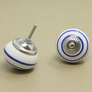 Detail showing white ceramic drawer knob with blue ring patterns and silver metal base