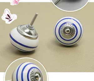 Detail of round ceramic cabinet knob with blue stripes and mounting bolt hardware