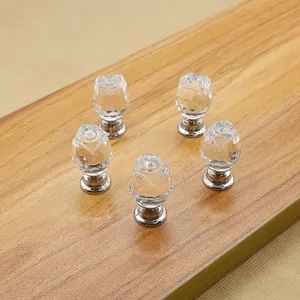 Set of 5 clear crystal rose drawer pulls with silver bases on wood surface