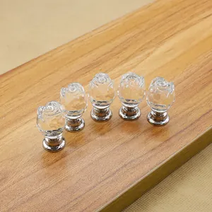 Detailed view of five 20mm crystal rose flower cabinet knobs on a rustic wood surface