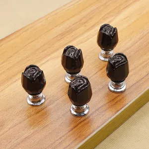 Five black rose crystal glass drawer knobs with silver metal bases on wooden board
