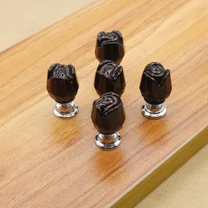 Set of 5 black rose crystal drawer knobs with silver metal bases on wooden background