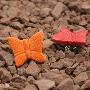 Red butterfly ceramic drawer knob with silver metal base on a stone background