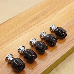 Detailed view of five black crystal rose knobs with silver metal bases for furniture