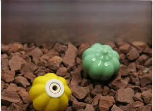 Detailed macro view of yellow and green pumpkin-shaped ceramic drawer pulls with metal holes