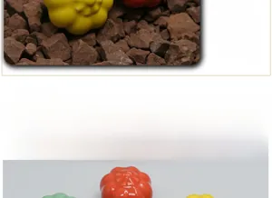 Macro shot of pumpkin-shaped ceramic knobs in red, yellow, and green colors