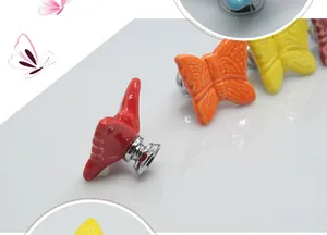 Detail of butterfly ceramic drawer pulls with silver bases in multiple bright colors