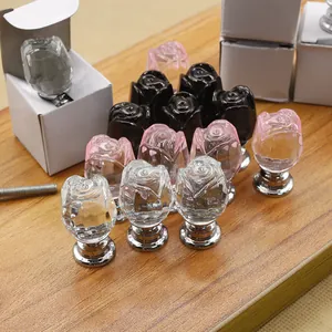 Macro shot of rose-shaped crystal glass knobs in clear pink and black with silver bases