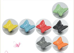 Detail of butterfly-shaped ceramic cabinet knobs in various colors with metal bases