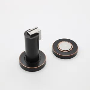 Detail view of a matte black and red bronze cylindrical magnetic door stopper
