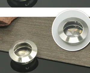 Dettaglio maniglia rotonda da incasso in acciaio inox spazzolato per mobili moderni