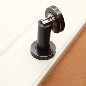 Macro view of magnetic door stopper in bronze finish mounted on a white door