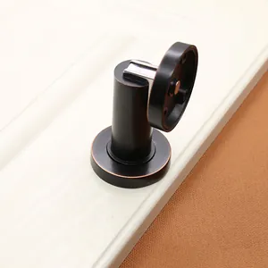 Detail of magnetic door stopper in matte black and antique bronze brushed finish
