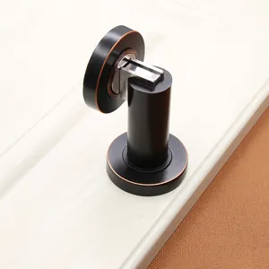 Detail view of matte black magnetic door stopper with vintage copper trim on metal