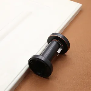 Detailed view of matte black magnetic door stopper with bronze edges and mounting base