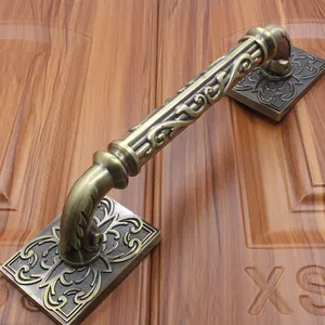 Detailed close-up of antique bronze door handle with ornate European floral carvings