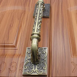 Detailed close-up of antique bronze door handle with ornate floral carvings on wood