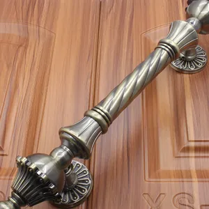 Macro view of antique bronze door handle with spiral grip and ornate floral base carvings