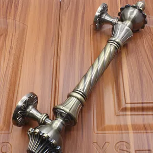 Close-up of European antique bronze door handle with spiral grip and relief carving