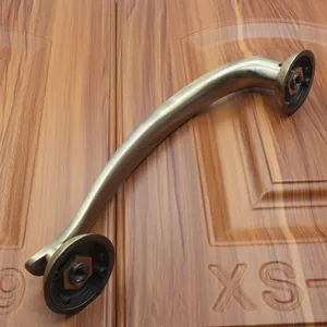 Detail of antique bronze curved door handle with brushed texture and mounting bases