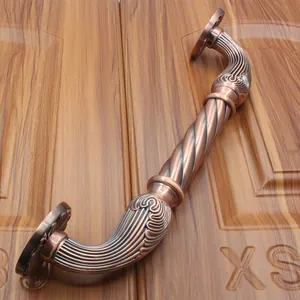 Close-up of European antique bronze door handle with spiral twist and embossed patterns