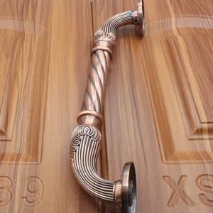 Detail showing red bronze antique door handle with spiral texture and floral carvings