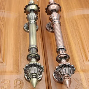 Detailed close-up of antique bronze and red copper door handles on wooden surface