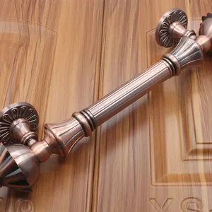 Detail of European antique bronze door handle with striped texture and floral base
