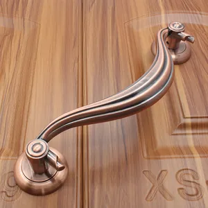 Detail of S-shaped antique bronze door handle with brushed metal texture and round bases
