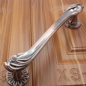 Detail of European antique red bronze door handle with brushed texture on wooden panel
