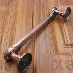 Detail of antique bronze door handle with brushed metal finish on wooden surface