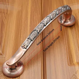 Detail view of Antique Red Bronze door handle with ornate floral carvings on wooden surface