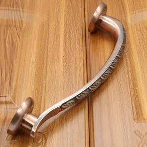 Detail view of European antique bronze door handle with ornate embossed scroll patterns