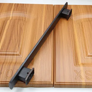 Detail of a minimalist dark bronze metal handle installed on natural grain wooden doors