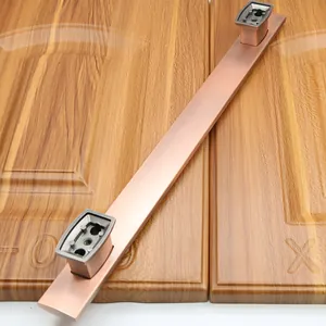 Detail of vintage bronze metal door handle with brushed texture on wooden panel